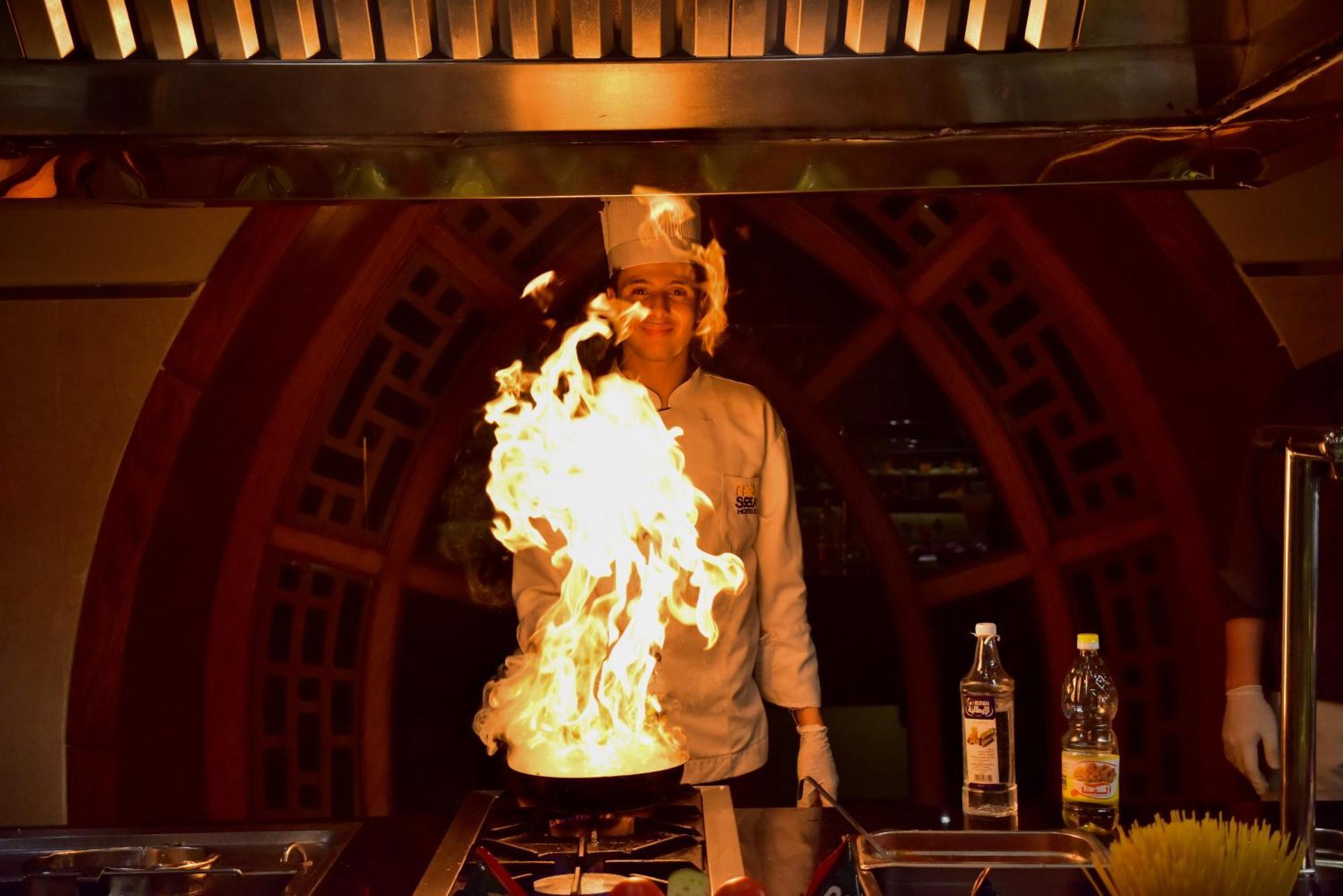 The Grand Hotel Sharm El Sheikh Εξωτερικό φωτογραφία A chef cooking with a flaming wok